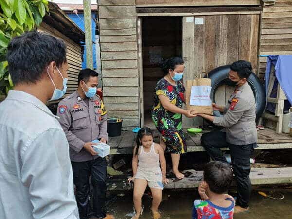 Kapolsek Sandai Rela Arungi Banjir untuk Berikan Bantuan Sembako ke Warga