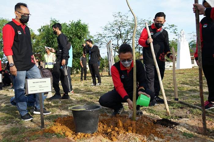 Wali Kota Edi Rusdi Kamtono menyiram pohon Tabebuya yang ditanamnya di Taman Cahaya Madani Gayung Bersambut Kota Singkawang.
