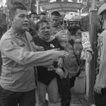 Ade Armando saat dievakuasi oleh pihak kepolisian setelah babak belur dianiaya massa