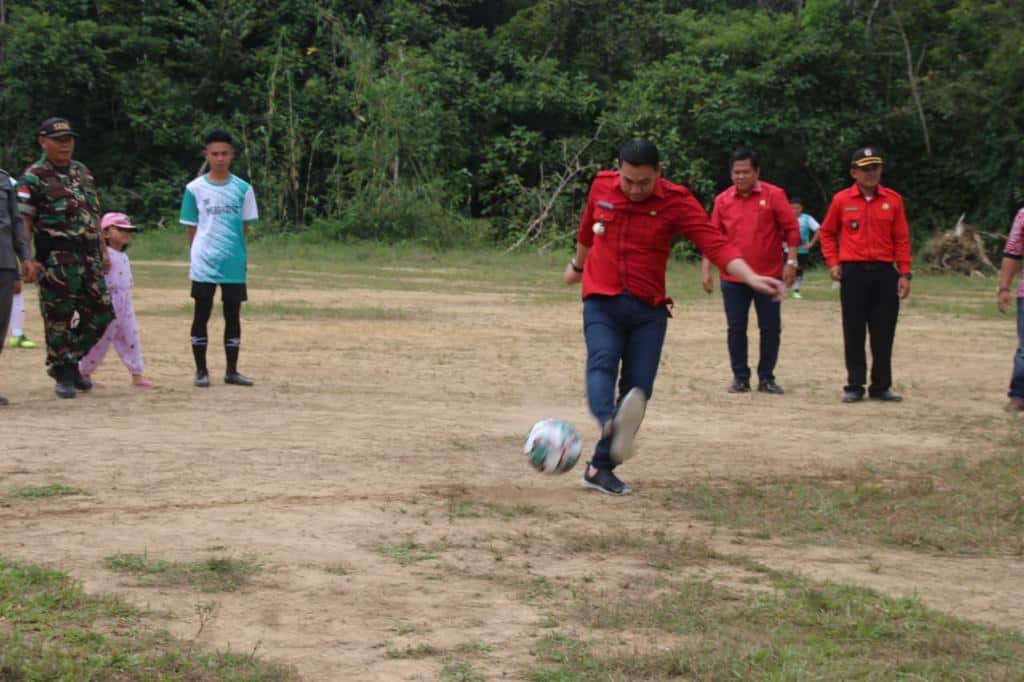 Bupati Kapuas Hulu, Fransiskus Diaan melakukan tentangan perdana sebagai tanda dimulainya Open Turnamen Sepak Bola di Dusun Upak, Kecamatan Empanang, Kabupaten Kapuas Hulu, Jumat (22/7/2022) siang. (Foto: Istimewa)