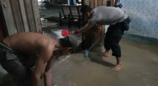 Personel jajaran Polsek Monterado membantu warga menguras air yang menggenangi rumahnya. (Foto: Istimewa)
