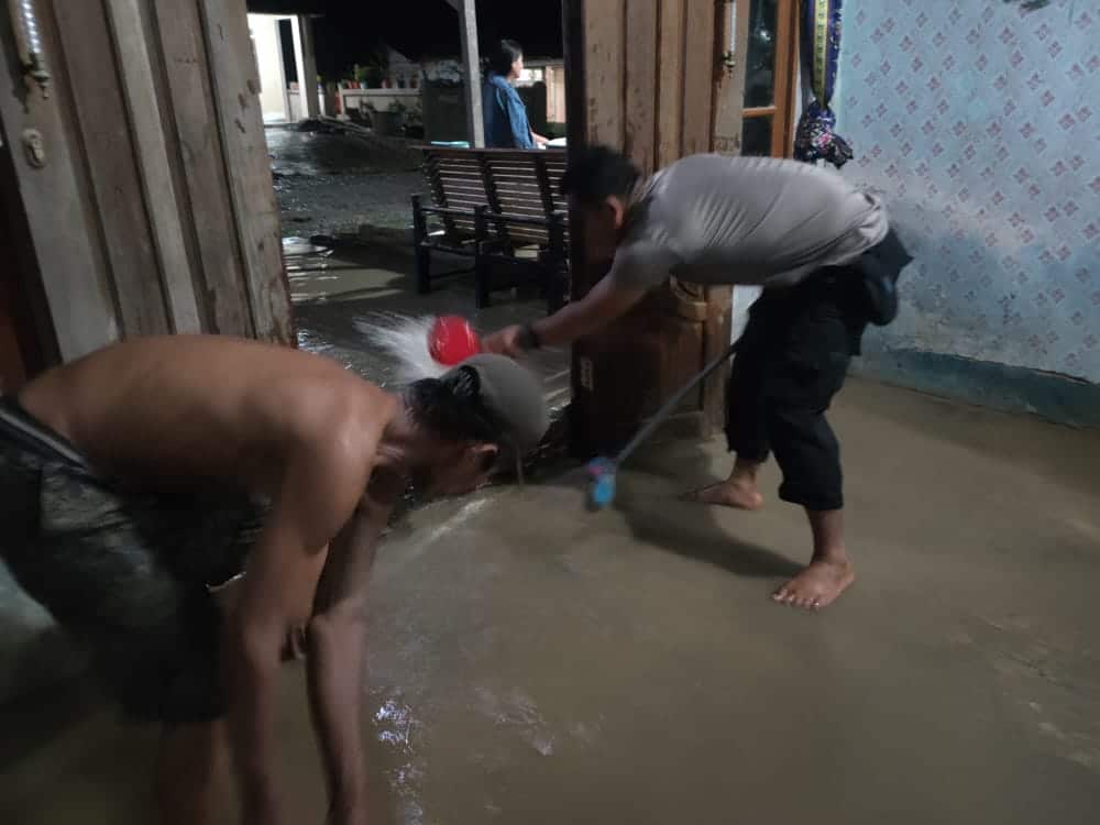 Personel jajaran Polsek Monterado membantu warga menguras air yang menggenangi rumahnya. (Foto: Istimewa)