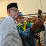 Gubernur Kalbar, Sutarmidji berfoto selfie bersama salah satu jemaah di sela-sela melakukan penyambutan secara seremonial kedatangan jemaah haji Kalbar di Hotel Kapuas Palace Pontianak, Jumat (29/07/2022). (Foto: Istimewa)