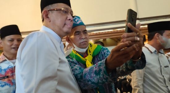 Gubernur Kalbar, Sutarmidji berfoto selfie bersama salah satu jemaah di sela-sela melakukan penyambutan secara seremonial kedatangan jemaah haji Kalbar di Hotel Kapuas Palace Pontianak, Jumat (29/07/2022). (Foto: Istimewa)
