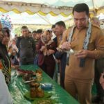 Bupati Kapuas Hulu, Fransiskus Diaan mencicipi kuliner khas tradisional pada Festival Makanan Tradisional di Desa Lanjak Deras, Kecamatan Batang Lupar, Senin (22/08/22) pagi. (Foto: Istimewa)