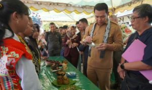 Bupati Kapuas Hulu, Fransiskus Diaan mencicipi kuliner khas tradisional pada Festival Makanan Tradisional di Desa Lanjak Deras, Kecamatan Batang Lupar, Senin (22/08/22) pagi. (Foto: Istimewa)