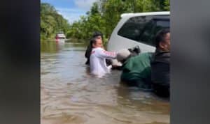 Wakil Bupati kapuas Hulu, Wahyudi Hidayat bersama rombongan bahu-membahu menarik mobil dinas yang terseret arus ke lokasi yang dangkal. (Foto: Istimewa)