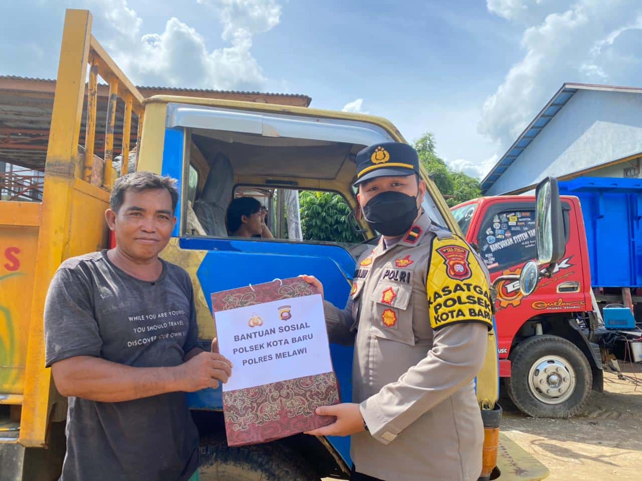Personel Polsek Kota Baru membagikan paket sembako kepada salah satu pengemudi truk, Selasa (06/09/2022). (Foto: BS/KalbarOnline.com)