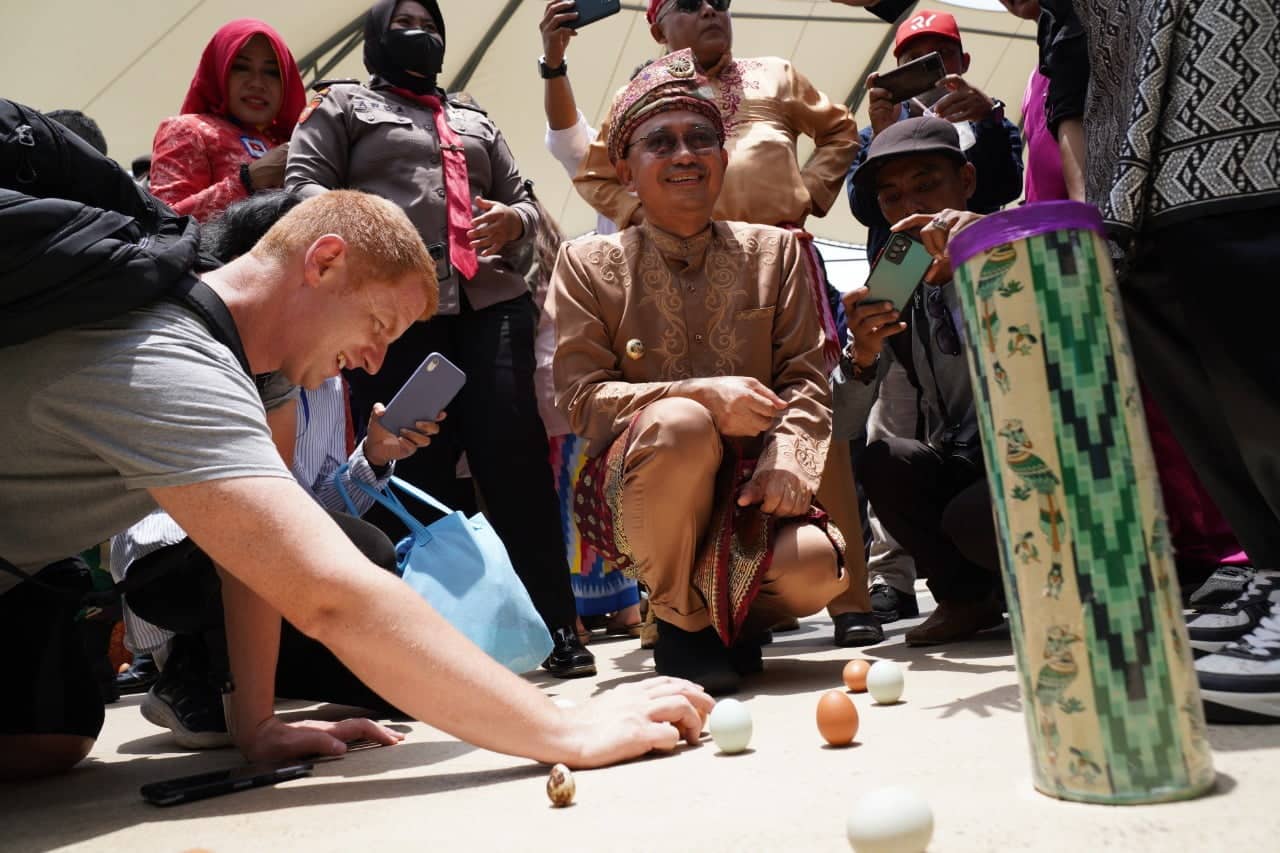 Turis asing asal Kanada ikut mendirikan telur bersama Wali Kota Pontianak, Edi Rusdi Kamtono pada Pesona Kulminasi Matahari di Tugu Khatulistiwa. (Foto: Prokopim/Kominfo for KalbarOnline.com)