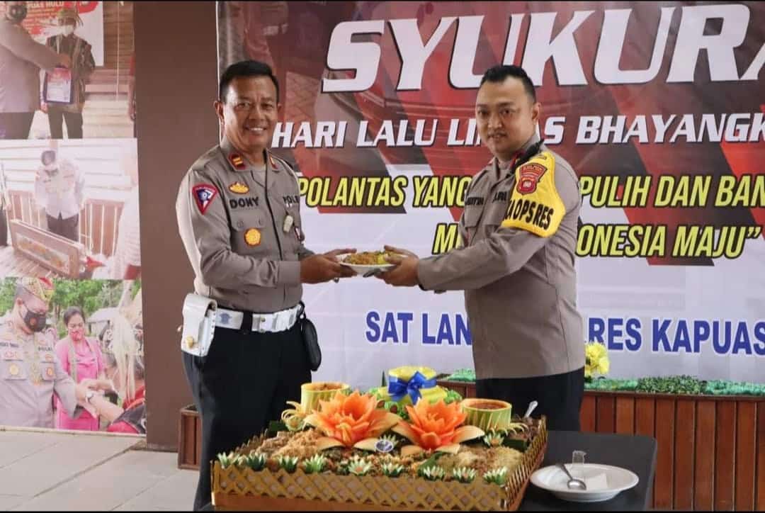 Wakapolres Kapuas Hulu, Kompol Adhitya Octorio Putra menyerahkan potongan tumpeng kepada personel Satlantas Polres Kapuas Hulu. (Foto: Ishaq)