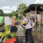 Kapolsek Manis Mata, IPTU Adi Sudirman bersama anggotanya mendatangi lokasi banjir dan memberikan bantuan sembako kepada masyarakat. (Foto: Adi LC)
