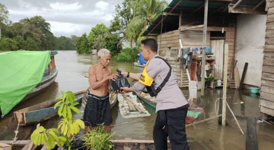 Kapolsek Manis Mata, IPTU Adi Sudirman bersama anggotanya mendatangi lokasi banjir dan memberikan bantuan sembako kepada masyarakat. (Foto: Adi LC)
