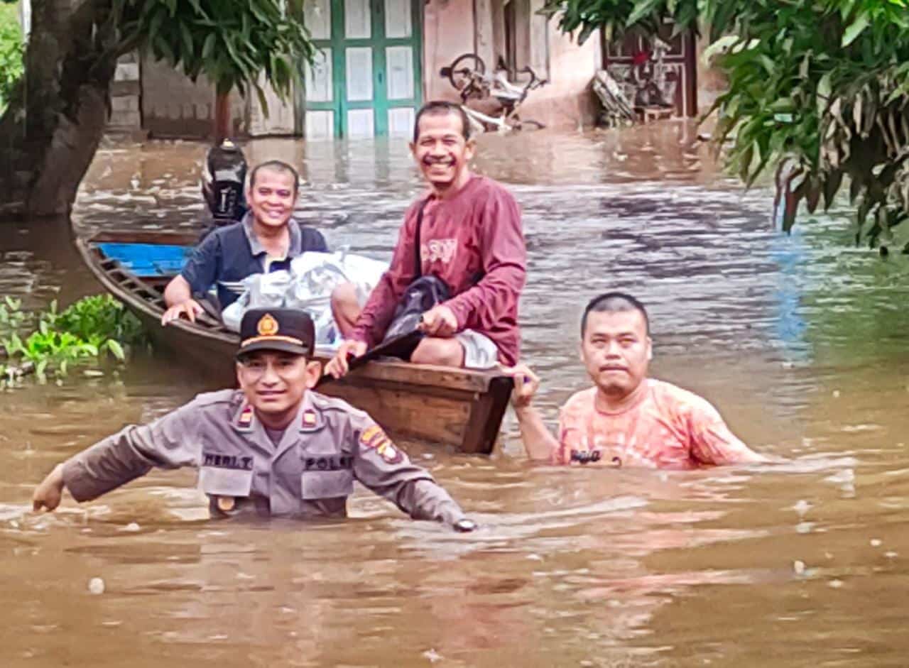 Kapolsek Kapuas jajaran Polres Sanggau, IPTU Heri Triyana menyusuri wilayah banjir di lingkungan Liku, Kelurahan Beringin, untuk memberikan bantun kepada warga terdampak. (Foto: Jauhari)