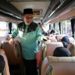 Ketua Umum LPTQ Kota Pontianak, Mulyadi berbincang dengan peserta kafilah Kota Pontianak di dalam bus sebelum keberangkatan. (Prokopim For KalbarOnline.com)