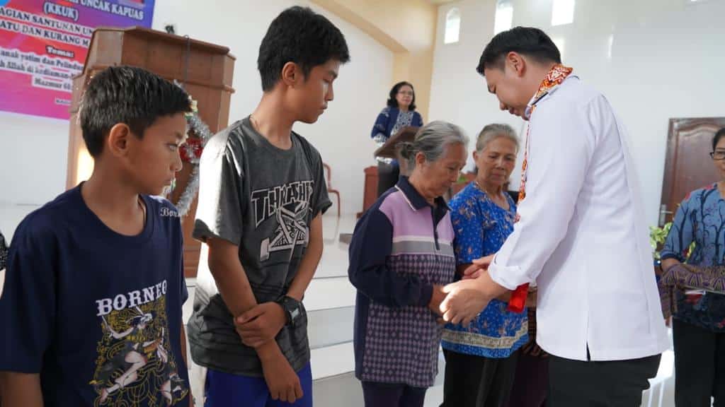 Bupati Kapuas Hulu, Fransiskus Diaan menyerahkan pembagian santunan untuk anak yatim/piatu dan kurang mampu Kristen di Gereja Bukit Sion Badau, Rabu (30/11/2022). (Foto: Ishaq)