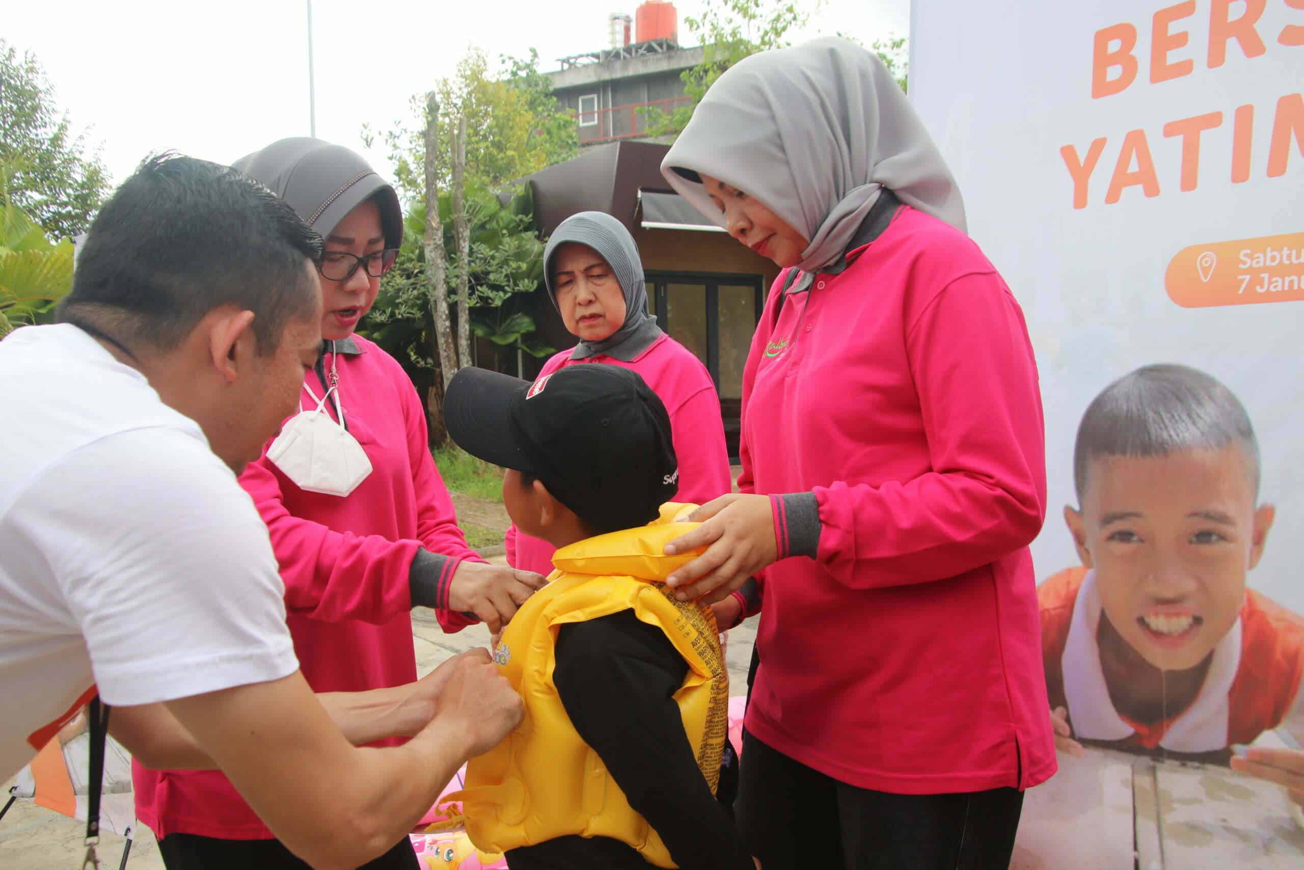 Ketua Dharma Wanita Persatuan Provinsi Kalimantan Barat, Windy Prihastari memasangkan pelampung kepada anak yang tidak bisa berenang. (Foto: Biro Adpim For KalbarOnline.com)