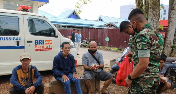 Prajurit Yonif RK 644 Walet Sakti membagikan puluhan paket nasi bungkus kepada masyarakat di Kapuas Hulu. (Foto: Ishaq)