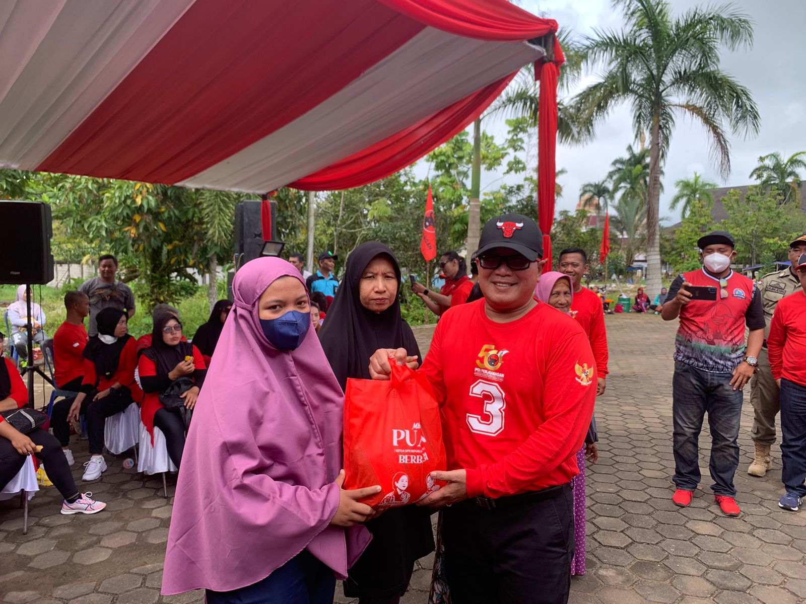 Bendahara DPD PDI Perjuangan Kalbar, Sujiwo menyerahkan bantuan paket sembako kepada warga di sela-sela melakukan penghijauan di Taman Teratai Kabuaten Mempawah. (Foto: Jauhari)