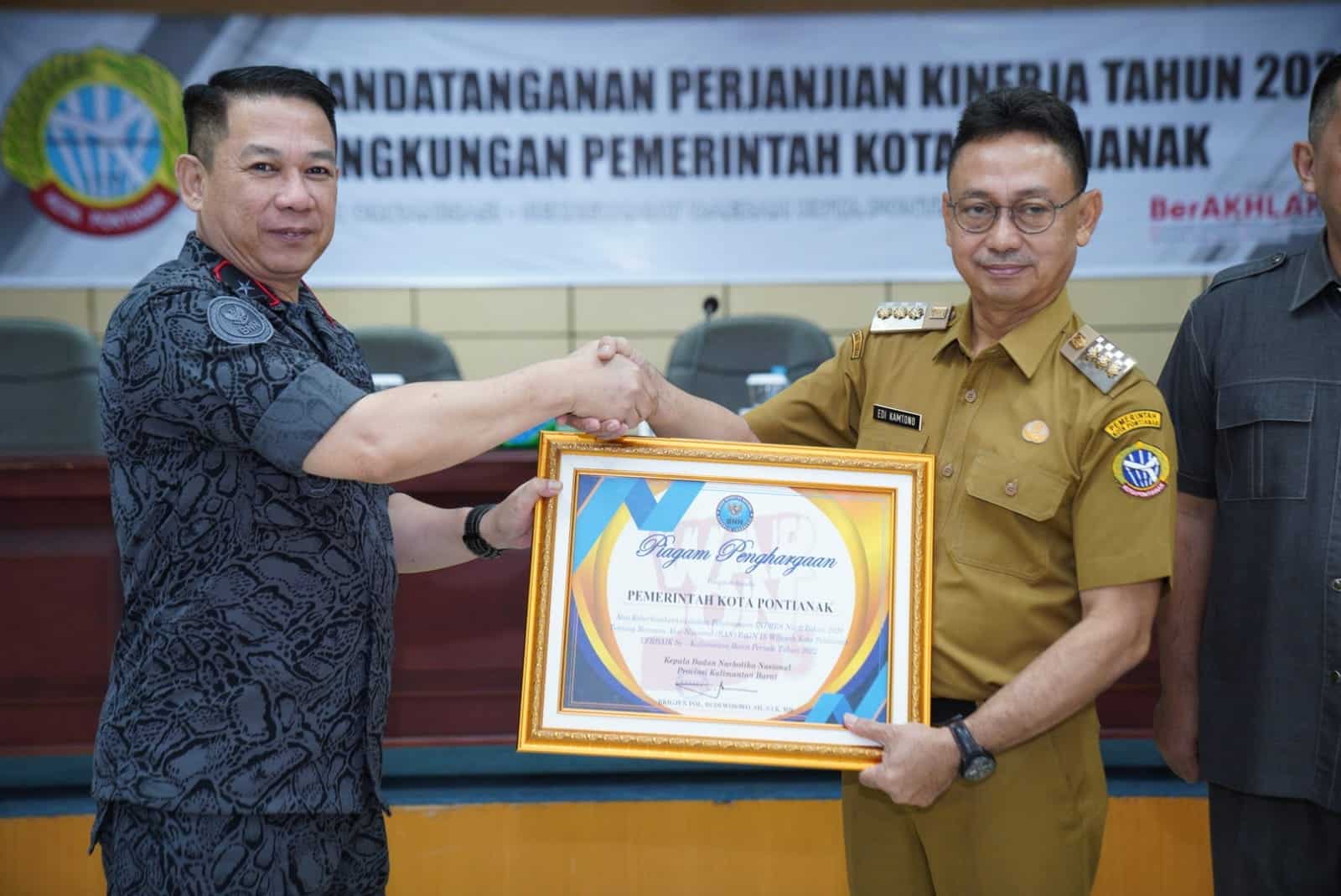 Kepala BNN Provinsi Kalbar, Brigjen Pol Budi Wibowo menyerahkan piagam penghargaan kepada Wali Kota Pontianak, Edi Rusdi Kamtono. (Prokopim For KalbarOnline.com)