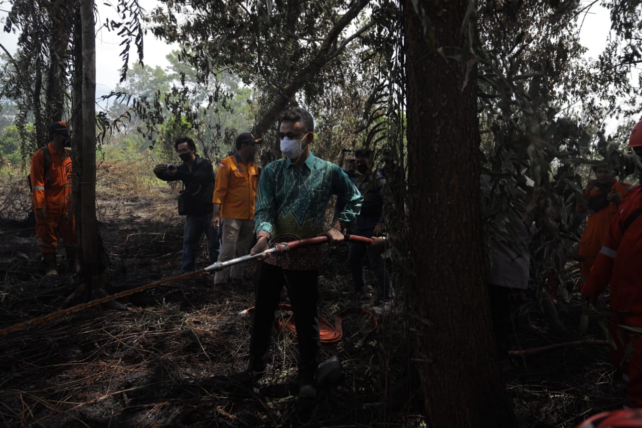 Wali Kota Pontianak, Edi Rusdi Kamtono memadamkan api yang masih menyala di lokasi kebakaran lahan. (Foto: Prokopim/Kominfo For KalbarOnline.com)