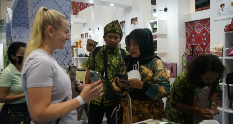 Ketua Dekranasda Kabupaten Kayong Utara, Yayuk Winarti Citra Duani memperkenalkan produk kerajinan Kayong Utara kepada turis asing, pada ajang INACRAFT 2023, di Jakarta Convention Center (JCC), Kamis (02/03/2023). (Foto: Prokopim)