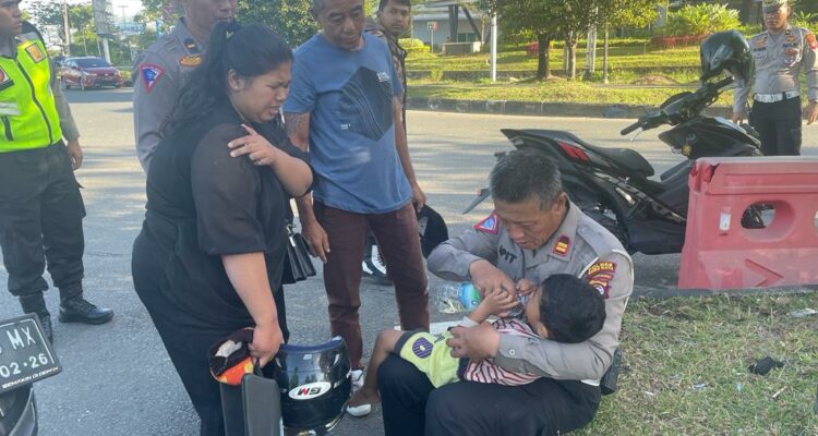 Kasat Lantas Polres Kubu Raya, IPTU Apit Junaedi memberikan pertolongan pertama kepada anak kecil yang menjadi korban kecelakaan di Jalan Mayor Alianyang tepatnya di Bundaran Transmart, Rabu (08/03/2023) pagi. (Foto: Jauhari)