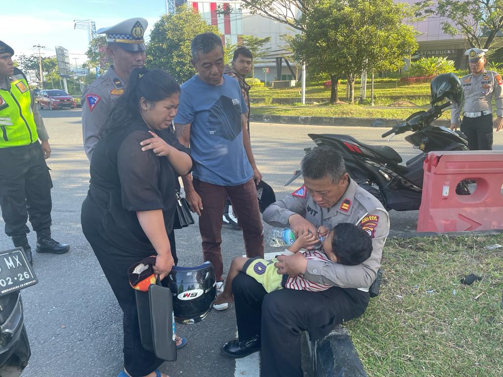 Kasat Lantas Polres Kubu Raya, IPTU Apit Junaedi memberikan pertolongan pertama kepada anak kecil yang menjadi korban kecelakaan di Jalan Mayor Alianyang tepatnya di Bundaran Transmart, Rabu (08/03/2023) pagi. (Foto: Jauhari)
