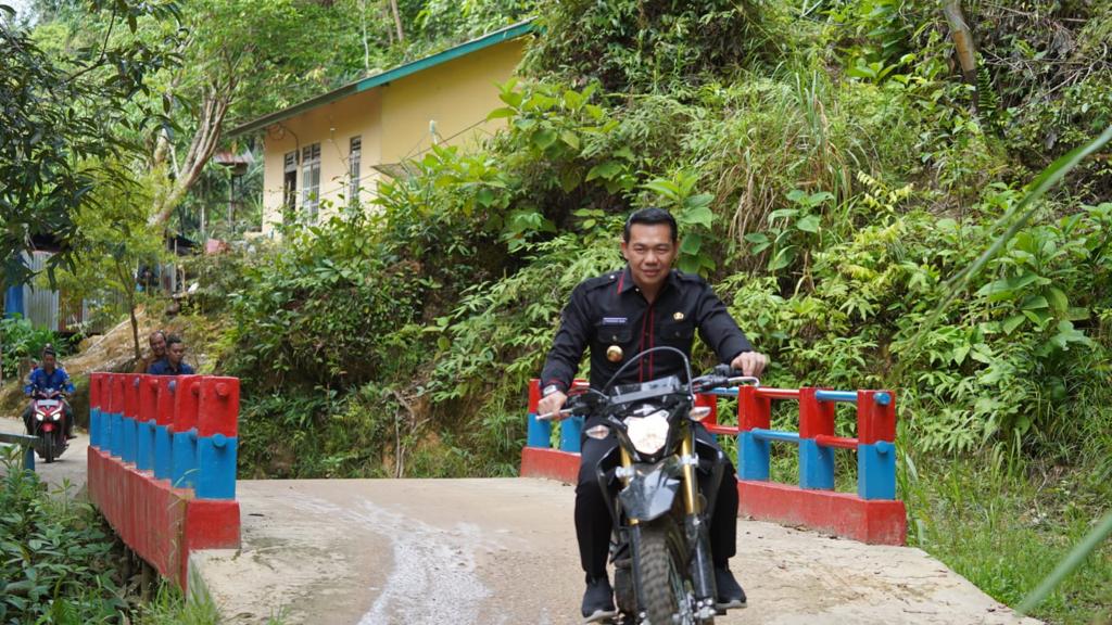 Menggunakan kendaraan roda dua, Bupati Kapuas Hulu, Fransiskus Diaan meninjau hasil pengerjaan jalan desa pada ruas Jalan Seberu - Nanga Lungu, Kamis (30/03/2023). (Foto: Ishaq)