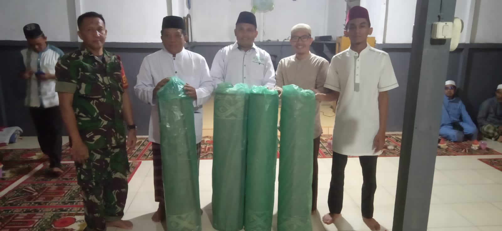 Manajemen PT Lestari Abadi Perkasa menyerahkan 4 gulung sajadah kepada pengurus Surau At-Takwa Desa Pebihingan. (Foto: Adi LC)