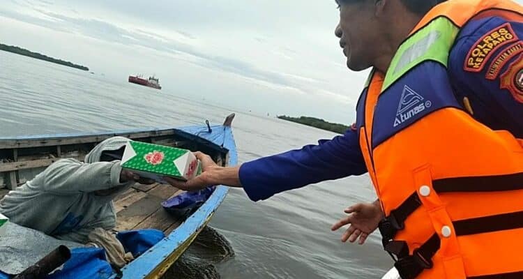 Personel Sat Polairud Polres Ketapang menyerahkan makanan untuk berbuka puasa (takjil) kepada nelayan pesisir. (Foto: Humas Polres Ketapang)