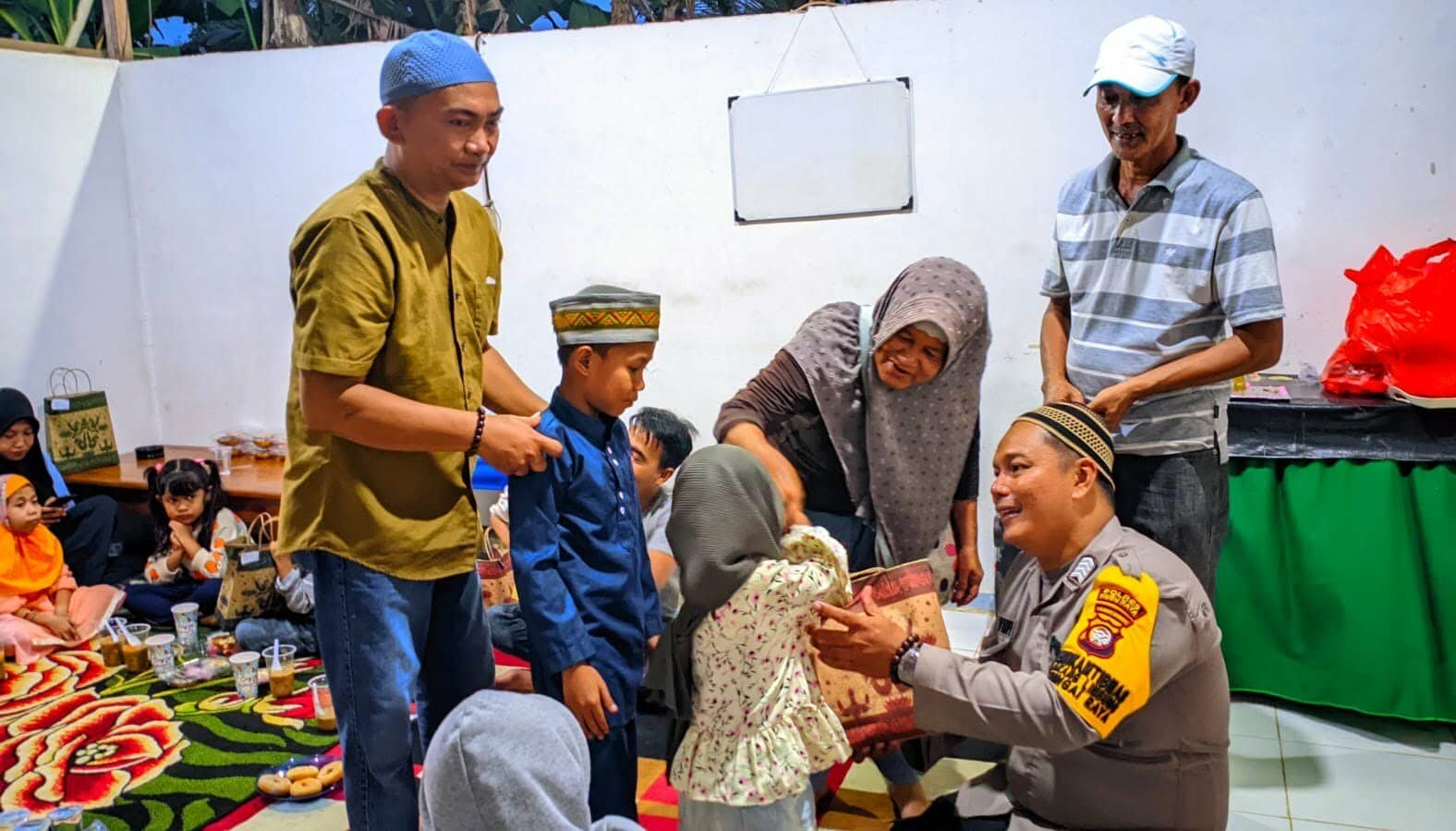 Polsek Sungai Raya bersama Masyarakat Peduli Sesama (MPS) Desa Arang Limbung menyerahkan santunan kepada 20 anak yatim piatu. (Foto: Humas Polres Kubu Raya)