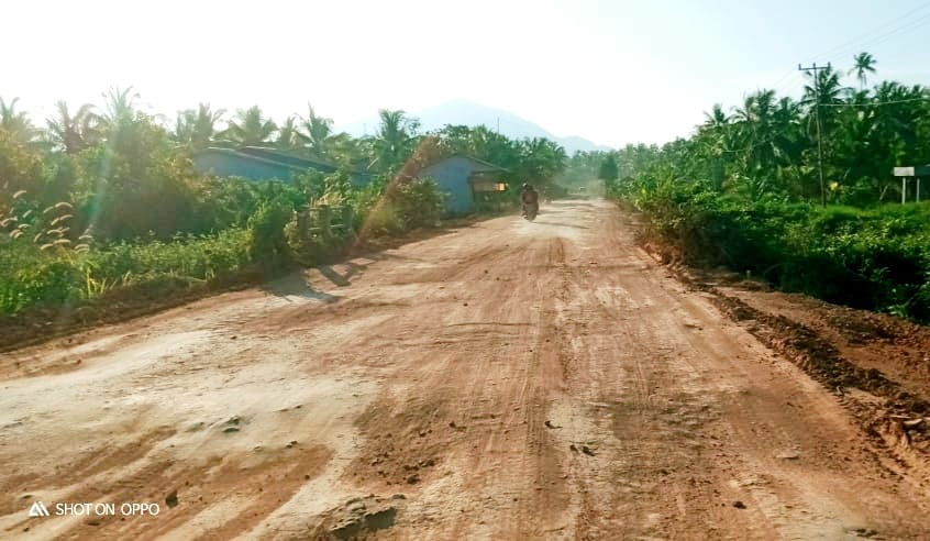 Jalan poros Kecamatan Sukadana yang licin dan berdebu. (Foto: Santo)