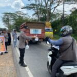 Personel Polres Kubu Raya membagikan takjil untuk pengguna jalan. (Foto: Humas Polres Kubu Raya)
