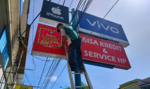 Petugas dari Tim Penertiban Pajak Daerah Kota Pontianak melakukan penyegelan dengan menempel stiker di papan reklame yang tidak membayar pajak. (Foto: Prokopim For KalbarOnline.com)