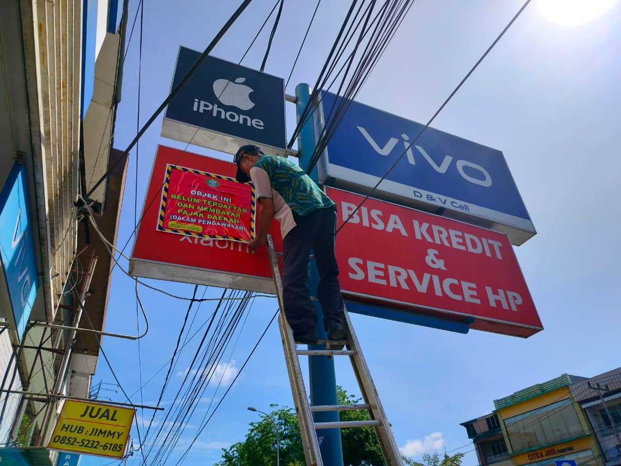 Petugas dari Tim Penertiban Pajak Daerah Kota Pontianak melakukan penyegelan dengan menempel stiker di papan reklame yang tidak membayar pajak. (Foto: Prokopim For KalbarOnline.com)