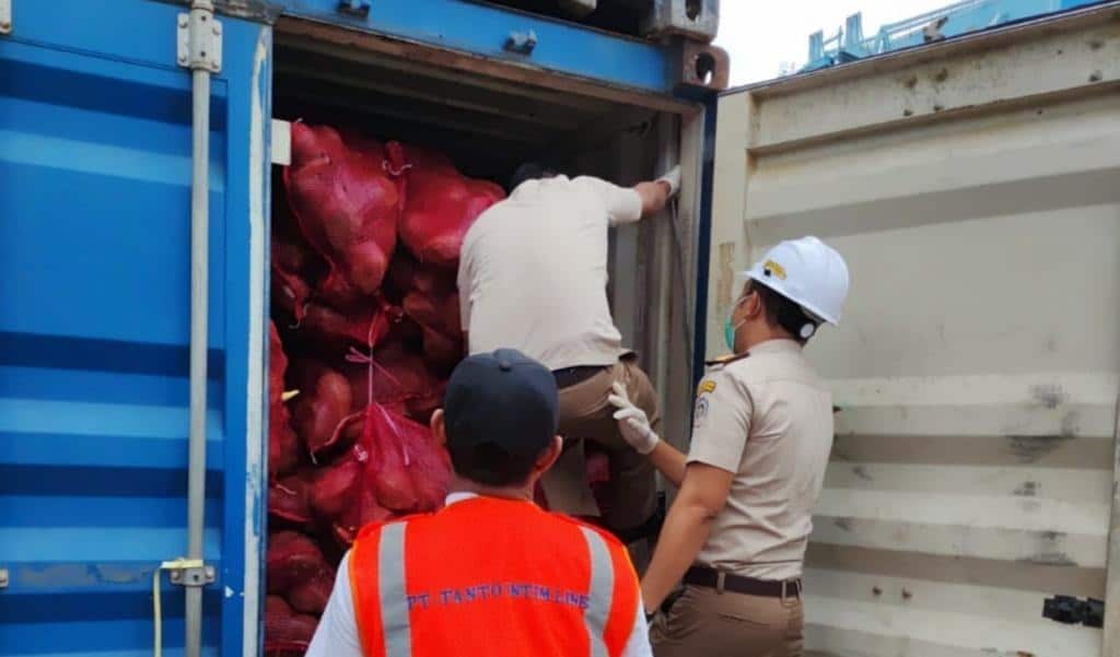 Petugas memeriksa 2 kontainer yang diduga berisi ribuan botol minuman beralkohol (minol). (Foto: Jauhari)