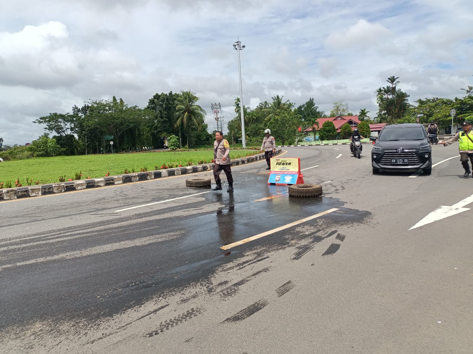 Petugas berupaya membersihkan tumpahan oli yang disebabkan oleh kecelakaan tunggal, di Bundaran Supadio Kubu Raya. (Foto: Polres Kubu Raya)