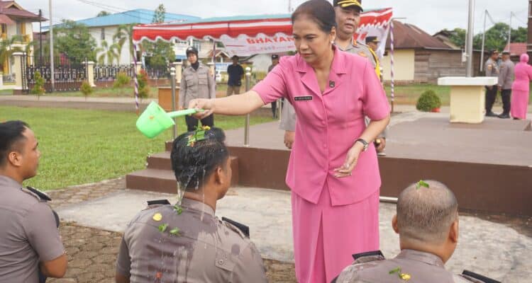Penyiraman air kembang sebagai salah satu prosesi upacara kenaikan pangkat personel di Polres Kapuas Hulu. (Foto: Ishaq)