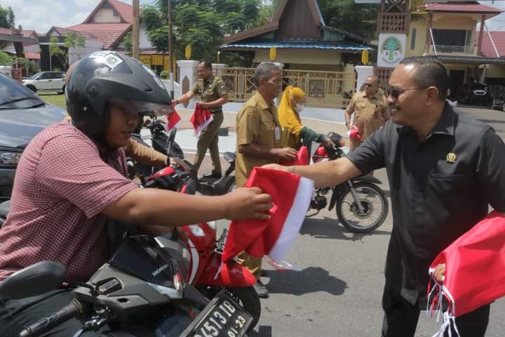 Aksi bagi-bagi bendera merah putih gratis kepada pengguna jalan yang melintas di depan Kantor DPRD Ketapang, Senin (31/07/2023) siang. (Foto: Adi LC)