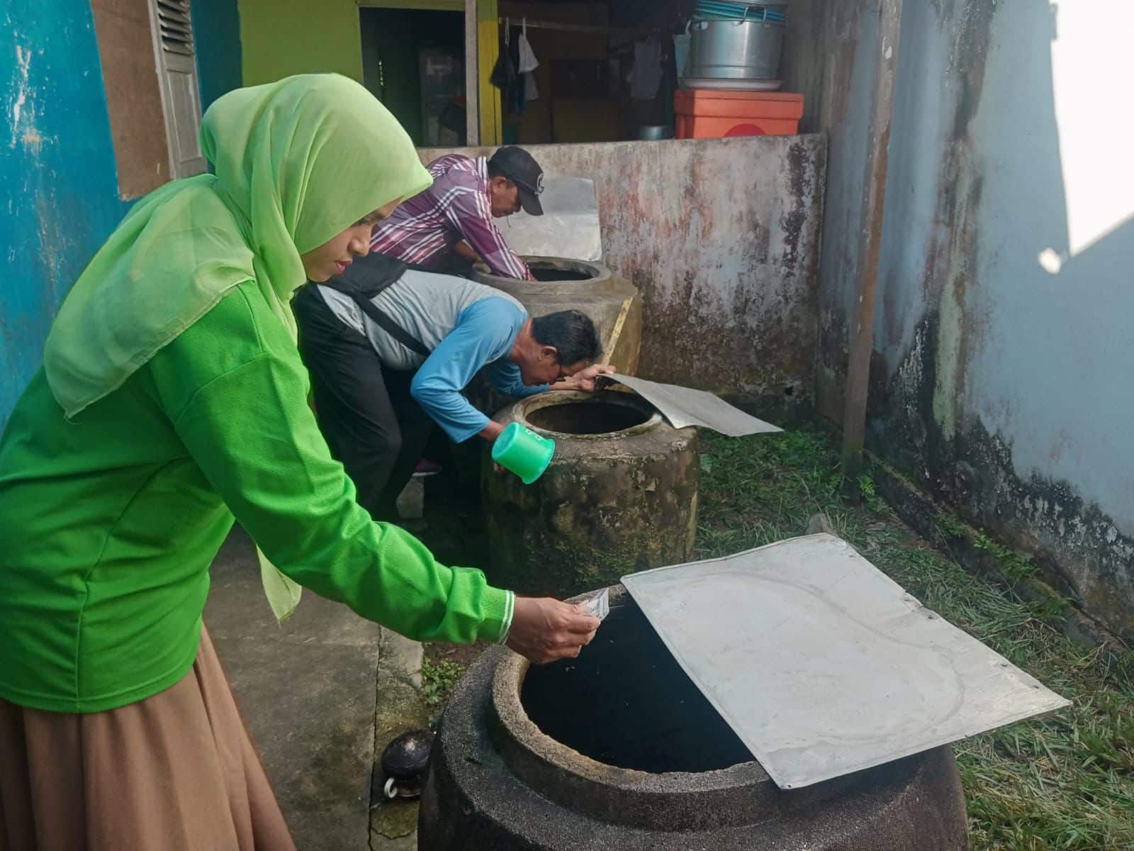 Penaburan bubuk abate sebagai salah satu upaya antisipasi perkembangbiakan nyamuk. (Foto: Indri)