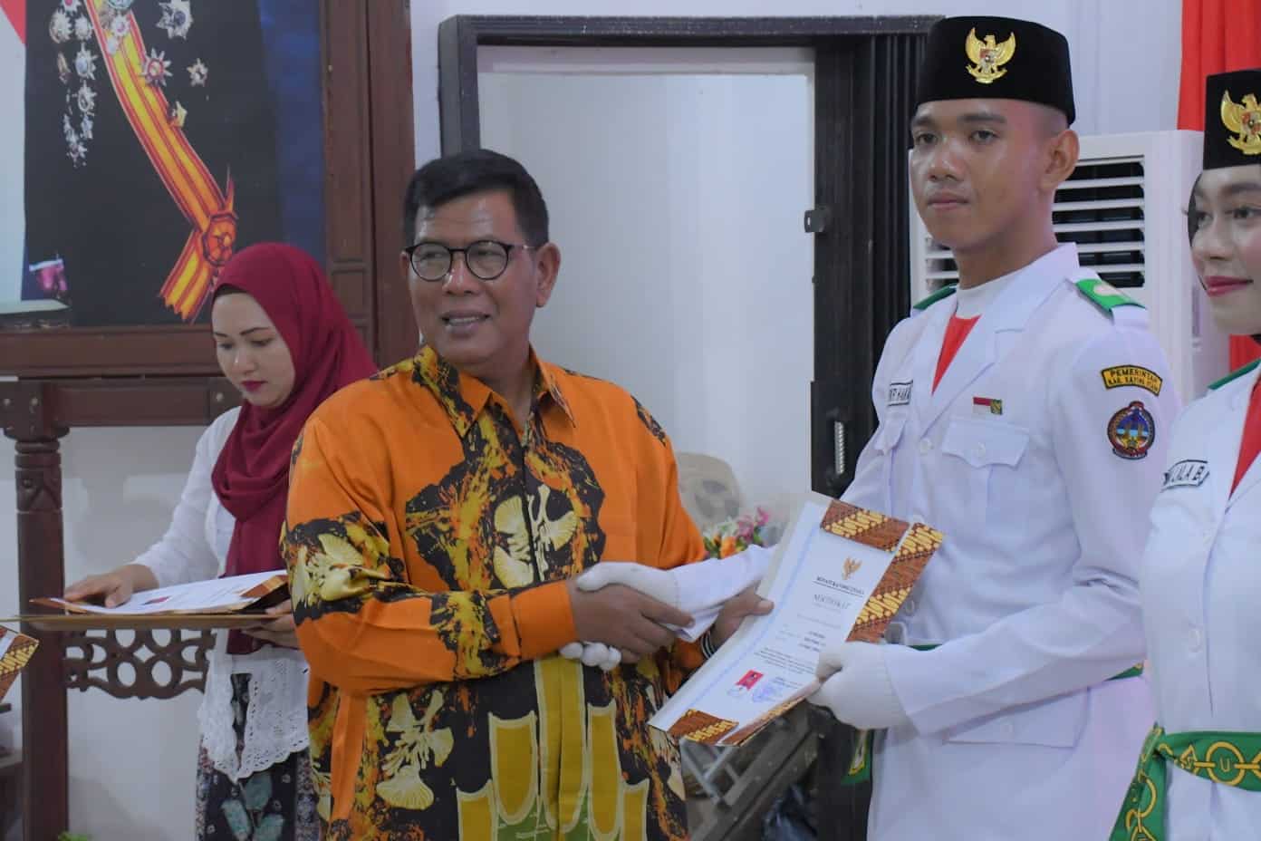 Bupati Kayong Utara, Citra Duani menyerahkan sertifikat penghargaan kepada salah seorang anggota paskibraka, di Aula Istana Rakyat, Kecamatan Sukadana, Kamis (17/08/2023) malam. (Foto: Santo)