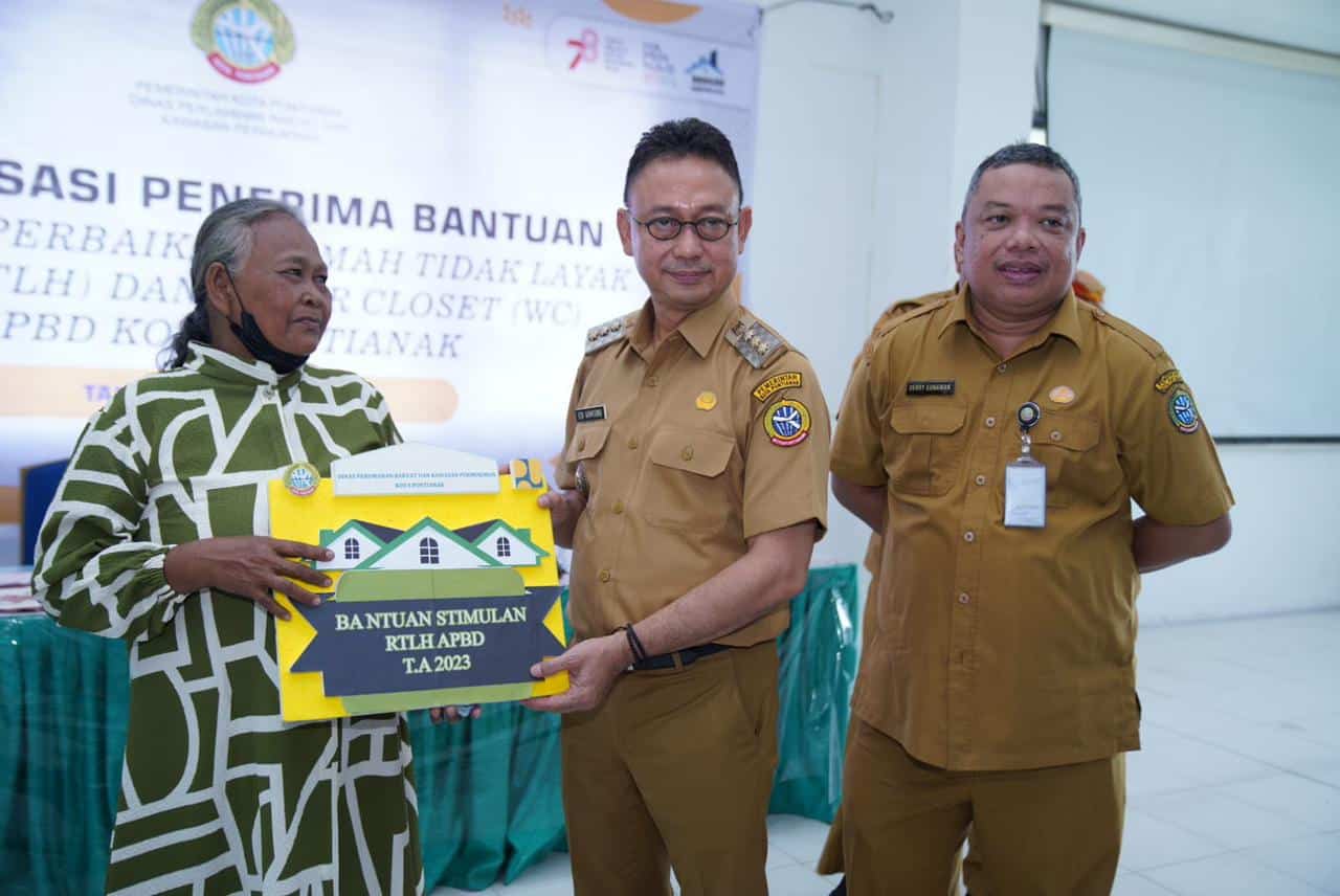 Wali Kota Pontianak, Edi Rusdi Kamtono menyerahkan secara simbolis bantuan Rumah Tak Layak Huni kepada salah seorang warga penerima manfaat. (Foto: Indri)