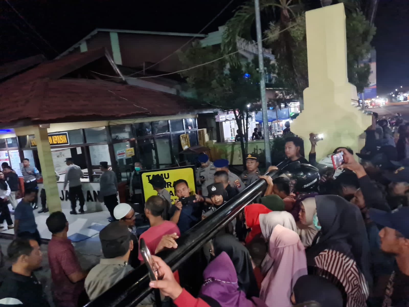 Massa yang berasal dari Desa Pesaguan Kanan, Kecamatan Matan Hilir Selatan berorasi di depan pagar Mapolres Ketapang meminta pelaku penyegelan kantor desa dibebaskan. (Foto: Adi LC)