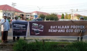 Massa Aksi saat membentang spanduk bertuliskan penolakan terhadap proyek Rempang Eco City di Trotoar perempatan traffic light RSUD dr Agoesdjam Ketapang, Jumat (22/09/2023). (Foto: Adi LC)