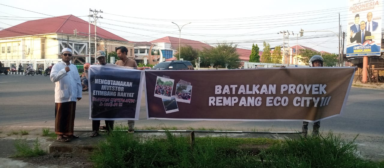 Massa Aksi saat membentang spanduk bertuliskan penolakan terhadap proyek Rempang Eco City di Trotoar perempatan traffic light RSUD dr Agoesdjam Ketapang, Jumat (22/09/2023). (Foto: Adi LC)