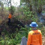 Tim Pemadaman Api Polres Kubu Raya sedang berupaya melakukan pemadaman api karhutla yang kembali menyala di TR 12 Dusun Sidomulyo, Desa Limbung, Kecamatan Sungai Raya, Kabupaten Kubu Raya, Sabtu (23/09/2023). (Foto: Jauhari)