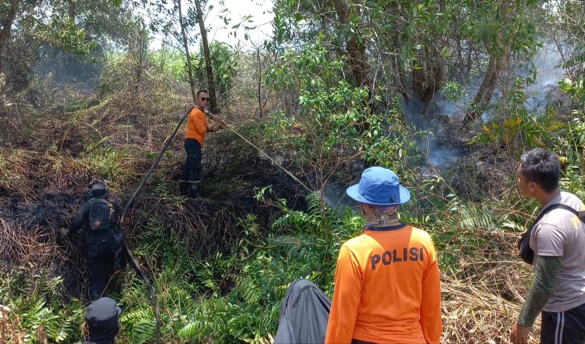 Tim Pemadaman Api Polres Kubu Raya sedang berupaya melakukan pemadaman api karhutla yang kembali menyala di TR 12 Dusun Sidomulyo, Desa Limbung, Kecamatan Sungai Raya, Kabupaten Kubu Raya, Sabtu (23/09/2023). (Foto: Jauhari)