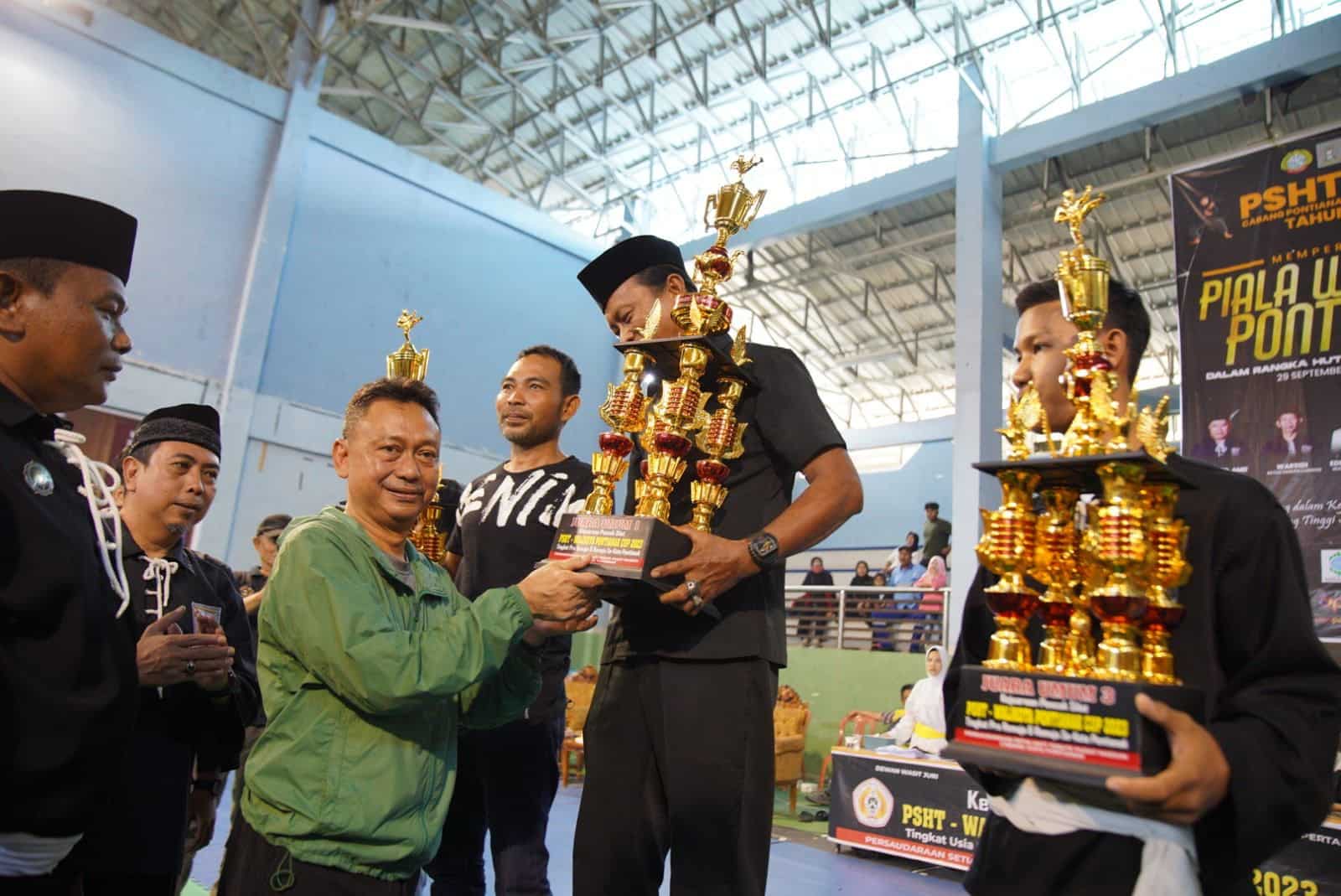 Wali Kota Pontianak, Edi Rusdi Kamtono menyerahkan piala kepada pemenang Kejuaraan Pencak Silat PSHT Cup Piala Wali Kota Pontianak 2023. (Foto: Prokopim Pontianak)