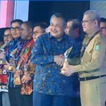 Penyerahan penghargaan oleh Gubernur Bank Indonesia, Perry Warjiyo kepada Pj Gubernur Kalbar, Harisson, di Hotel Sahid Jakarta, Selasa (03/10/2023). (Foto: Biro Adpim For KalbarOnline.com)