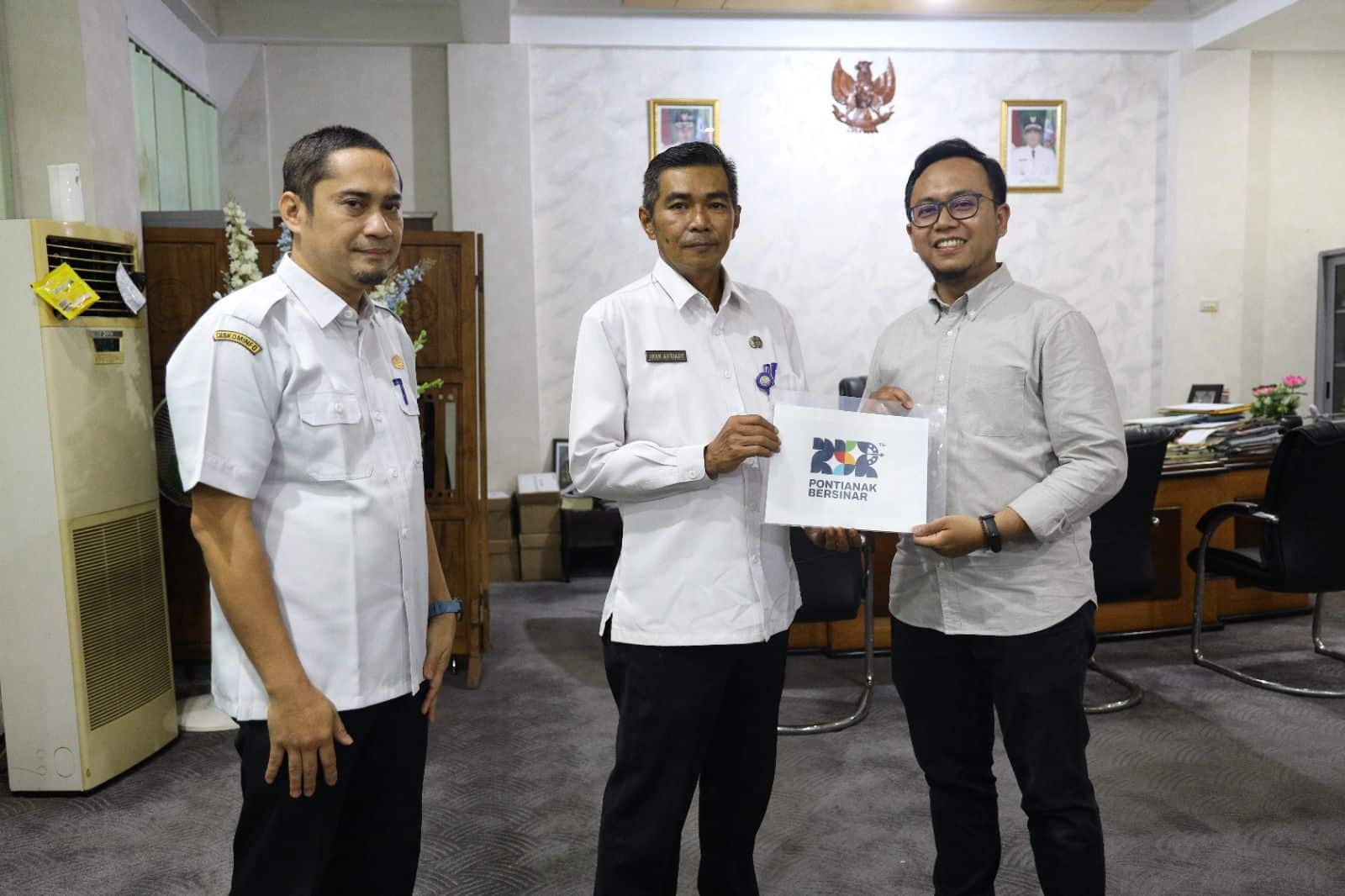 Ketua Panitia Hari Jadi ke-252 Pontianak, Iwan Amriady menerima hasil akhir sayembara logo dari CEO Pontinesia, Ridho Brilliantoro. (Foto: Kominfo/Prokopim Pontianak)